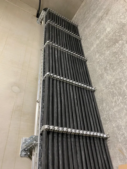 HKV Kabelverlegung – senkrecht verlegte Energiekabel, mit Kabelschellen an einer Metalltrasse befestigt